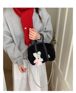 Detail of black plush handbag featuring a cute white rabbit charm and silver chain strap