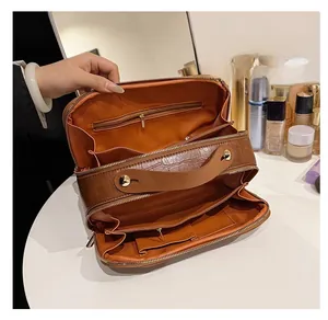 Detailed interior view of a brown crocodile pattern toiletry bag with layered dividers