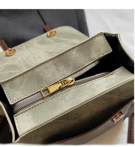 Detailopname van de gouden rits op de groene schoudertas met vintage textuur