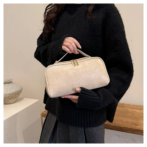 Detailed close-up of beige crocodile pattern portable storage bag with golden zippers