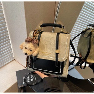 Detail van vintage crossbodytas met kralenrand en decoratieve teddybeertjes hanger