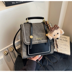 Detail van vintage grijze denim crossbody tas met parels en teddybeer bedeltje