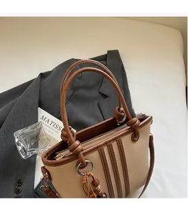 Detail view of the vintage bucket bag featuring contrast canvas, leather trim and tassels