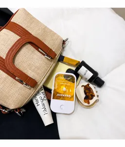 Detail view of the spacious beige woven handbag interior showing organized daily essentials