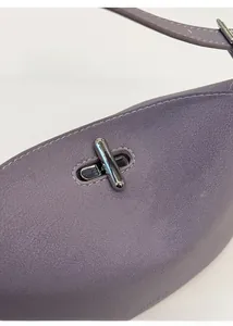 Close-up of purple lychee textured leather bag with shiny silver metal twist lock