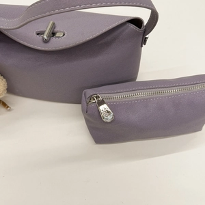 Detail view of lavender faux leather handbag with silver lock and matching mini coin purse