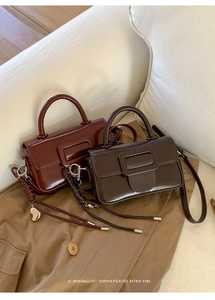 Detail of red and brown minimalist square handbags with woven pendants and glossy finish