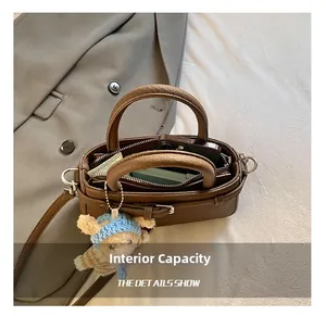 Detailed interior of a brown bucket bag showing zipper compartments and soft inner lining