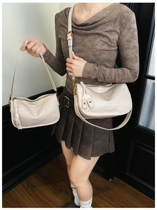 Detailed view of cream beige soft leather bags in two sizes with vintage gold hardware