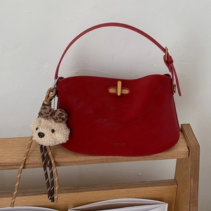 Chic red leather crescent shoulder bag with golden lock and cute plush bear charm