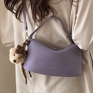 Chic purple hobo bag with teddy charm and silk scarf worn by a model in beige outfit