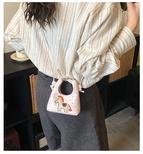 Detailaufnahme der rosa Mini-Handtasche mit Pferde-Stickerei und Herzmustern auf Leder