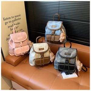 Detail showing four colors of mini backpacks with cloud texture and pearl bear charms