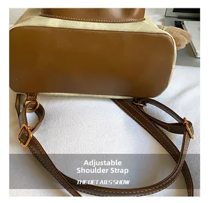 Detail showing adjustable brown leather shoulder strap with metal buckle on beige canvas bag