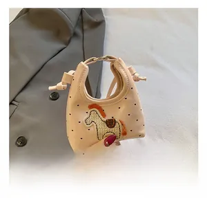 Detail der hellrosa Mini-Tasche mit Herzmuster und gesticktem Cartoon-Pony-Aufnäher