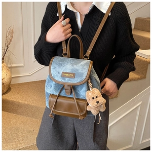 Detail view of mini vintage backpack in light blue denim and brown leather trim