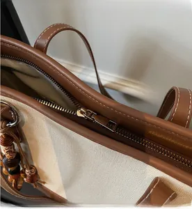 Detailopname van de soepele rits en bruin lederen bies op de canvas draagtas