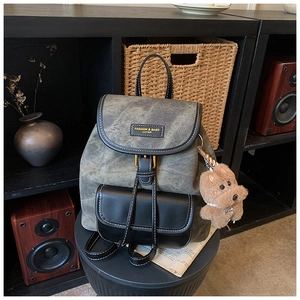 Close-up of vintage patchwork backpack with faux leather details and cute dog charm