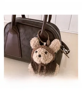 Dettaglio ravvicinato di un ciondolo a forma di orsetto di peluche su borsa Boston