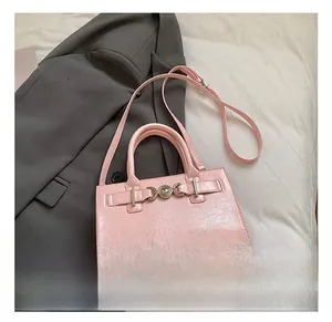 Detail van roze lakleren handtas met een zilveren hartvormige metalen gesp