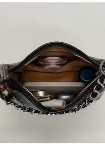 Vue intérieure montrant la capacité du sac bandoulière matelassé noir à chaîne