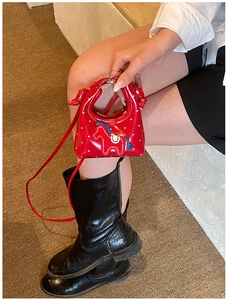 Detailansicht der roten Mini-Handtasche mit Punkten, Pferde-Stickerei und Schultergurt