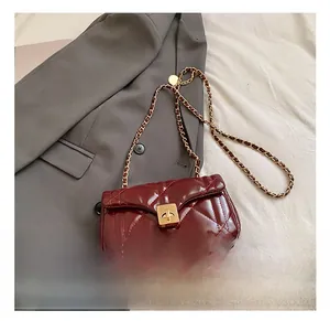 Detail showing wine red quilted leather texture and golden metal twist-lock chain