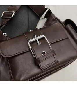 Detail of deep brown leather bag featuring polished silver metal buckle and strap hardware