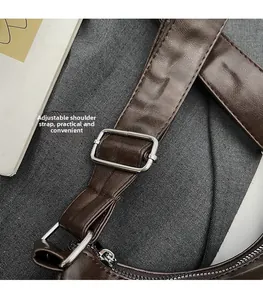 Detail of adjustable leather shoulder strap with silver buckle and neat stitching