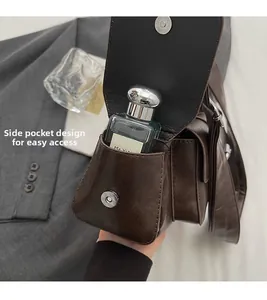 Detail view of side pocket with magnetic closure on vintage dark brown leather bag