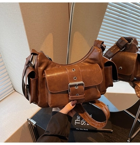 Detail of vintage brown shoulder bag showing front flap pocket with silver buckle