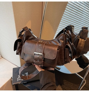 Close-up of retro brown shoulder bag with silver buckle and textured leather detail