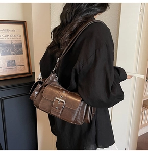 Detailed view of dark brown vintage motorcycle crossbody bag with side utility pockets