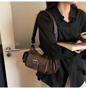 Detail of vintage dark brown multi-pocket crossbody bag with metallic buckle accent