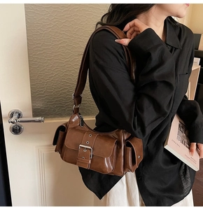 Retro brown leather shoulder bag detail on model featuring multiple flap pockets and oil-wax finish