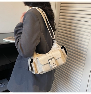 Detail view of cream vintage crossbody bag with multiple pockets and metal buckles