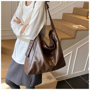 Brown vintage large capacity tote bag shown on model in a cozy interior setting