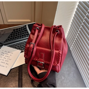 Vue détaillée d'un sac seau rouge vintage avec coutures tressées et cordon de serrage