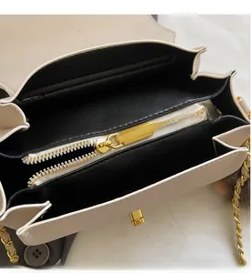 Détail de la fermeture éclair dorée et du compartiment interne du sac à bandoulière