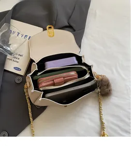 Vue de l'intérieur du sac en cuir beige avec chaîne dorée montrant la capacité de stockage