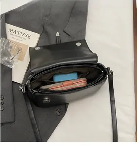 Interior view of black leather crossbody bag showing ample space for wallet and accessories