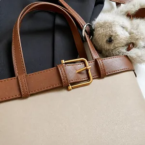 Gros plan détaillé sur la boucle dorée et les finitions métalliques du sac en cuir