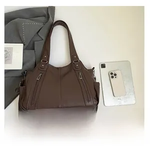 Macro detail of the dark brown lychee pattern leather and vertical zipper pockets on the tote
