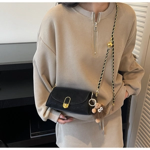 Sac bandoulière tendance en cuir noir mat avec chaîne dorée et breloque en peluche