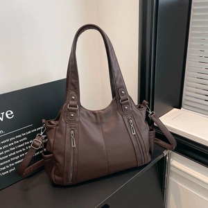 Detailed close-up of dark brown faux leather tote with functional double front zipper pockets