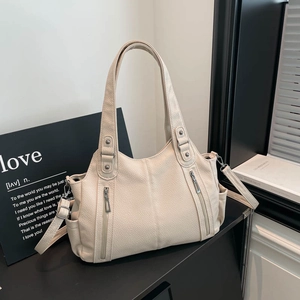 Detail view of lychee-patterned PU leather tote with rivets and adjustable shoulder strap