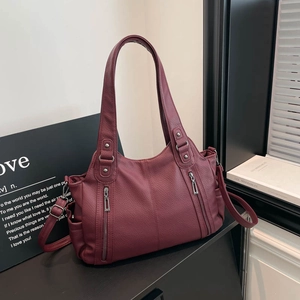 Detailed macro view of burgundy lychee grain leather texture and front zipper design