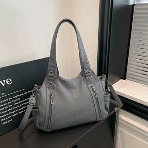 Close-up of grey litchi texture tote bag with vertical zippers and silver hardware