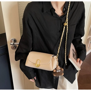 Sac oreiller beige chic avec chaîne dorée et détail de breloque monstre en peluche