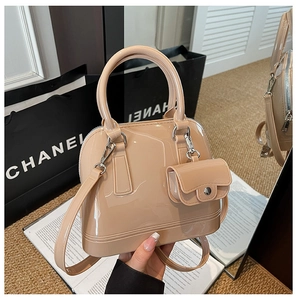 Elegante bolso de gelatina color albaricoque con mini monedero llevado en la mano
